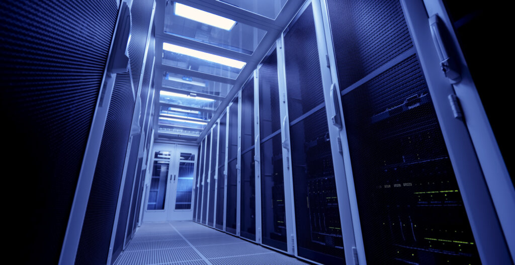 Interior of a modern data center with server racks and overhead lighting