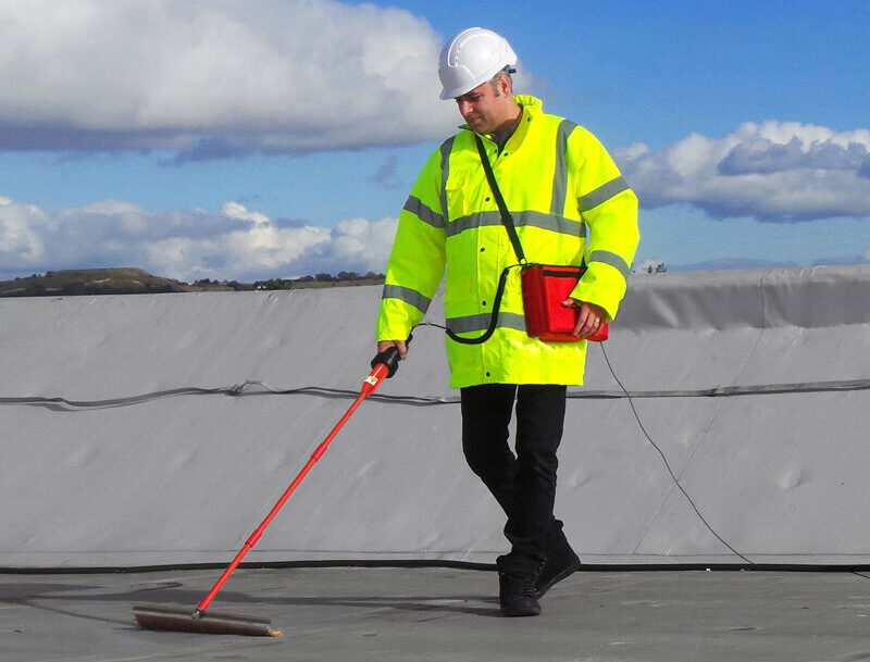 Technician using Electric Field Vector Mapping to detect leaks in a waterproofing membrane