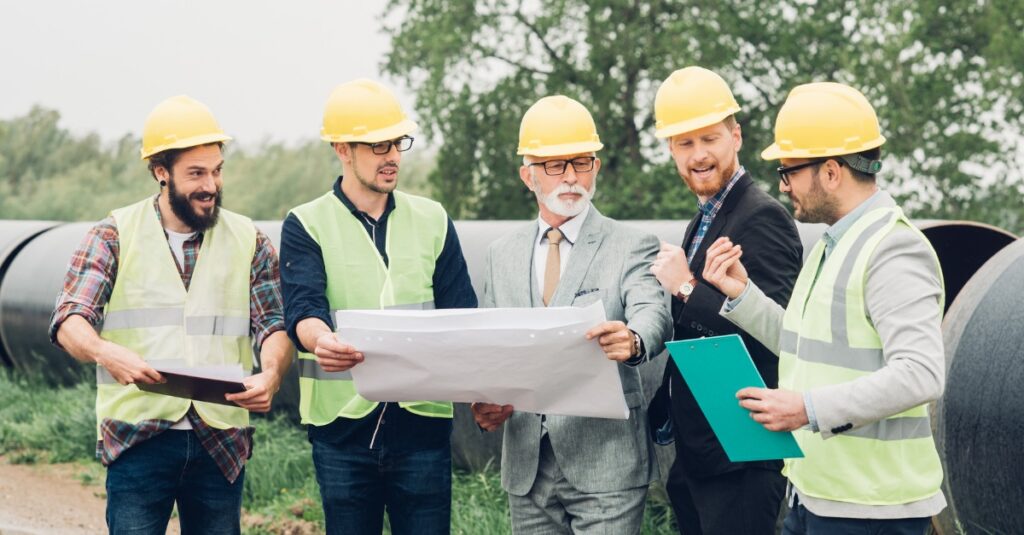 Construction team reviewing project plans to coordinate roofing closeout and leak testing